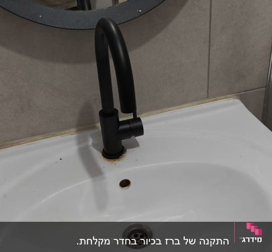 ברז שחור מודרני מותקן על כיור רחצה לבן